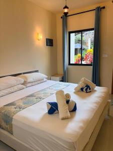 a bedroom with two beds with towels and a window at Dhigurah Dhonveli Boutique in Dhigurah