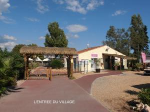 a building with a pavilion next to a walkway at le plein de bonheur in Fréjus