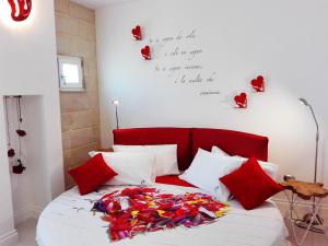 un letto con testiera rossa e cuori appesi al muro di Corte del Pascià a Lecce