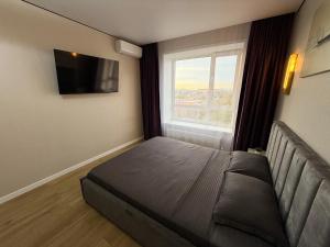 1 комнатная квартира в центре города на Победы 70 في كوستاناي: غرفة نوم صغيرة بها سرير ونافذة