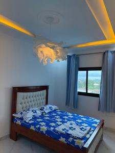 a bedroom with a bed with a blue ceiling at Aloha Suites Odza - by Skyline Residence Services in Yaoundé