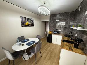 1 комнатная квартира в центре города на Победы 70 في كوستاناي: مطبخ وغرفة طعام مع طاولة وكراسي بيضاء