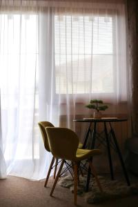 a table and two chairs in front of a window at Apartmán Mirka - Tatra Mountain Resort G104 in Veľká Lomnica