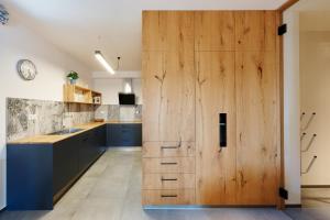 une grande porte en bois dans une cuisine avec des armoires bleues dans l'établissement Harrachov Retreat by Mumlava, à Harrachov