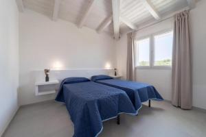 2 letti in una camera bianca con lenzuola blu di Luxi by NG Collection a Olbia