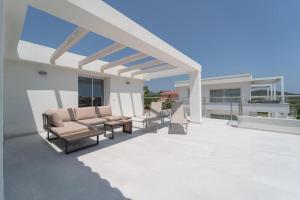 un patio con divani e sedie in cima a una casa di Luxi by NG Collection a Olbia