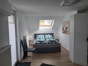 MüschedeにあるFerienwohnung Biancaのベッドと椅子のある寝室