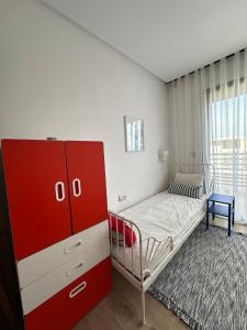 a bedroom with a red cabinet and a bed at Appart familial avec terrasse et piscine, à 2 pas de la plage des nations - Rabat in Sidi Bouqnadel +11 photos