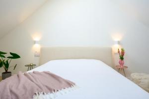 a white bed in a bedroom with two lights at Casa Mare Boutique in Blankenberge
