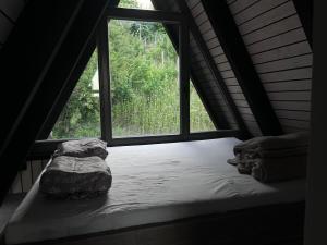 a bed in a room with a large window at A frame Miška in Nána