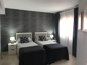 a bedroom with two beds and a wall at La Manga Club, Las Palmeras 12 in Cartagena