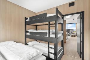 a bunk bed room with two bunk beds and a mirror at Arctic aurora lodge with jacuzzi and sauna in Lyngværet