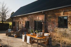 eine Terrasse mit einem Tisch und Stühlen sowie ein Backsteingebäude in der Unterkunft Ridgeway in Marlborough