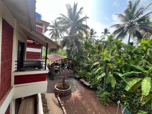 ein Gebäude mit vielen Palmen und Bänken in der Unterkunft Coral Beach Resort, Diveagar in Diveagar