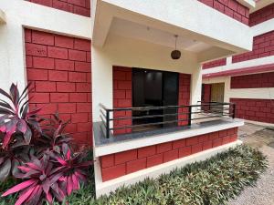 ein rotes Backsteingebäude mit Balkon in der Unterkunft Coral Beach Resort, Diveagar in Diveagar