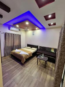 Zimmer mit einem Bett und einer blauen Decke in der Unterkunft Coral Beach Resort, Diveagar in Diveagar
