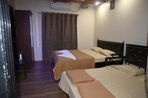 ein Hotelzimmer mit zwei Betten und einem Fenster in der Unterkunft Coral Beach Resort, Diveagar in Diveagar + 2 Fotos