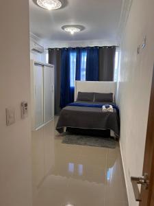 Un dormitorio con una cama y una cortina azul. en Luxury Royalty-1, en Santa Cruz de Barahona
