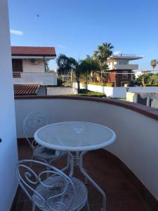 ein Tisch und zwei Stühle auf einem Balkon in der Unterkunft Villa Kora - elegance and comfort in Reggio Calabria in Reggio di Calabria