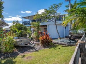 a white house with a yard with plants at Topsy Turvey self-contained accommodation Mangonui in Mangonui
