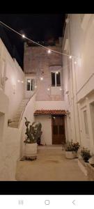 ein Gebäude mit einer Tür und einem Innenhof mit Topfpflanzen in der Unterkunft La Corte delle Arti in Matino