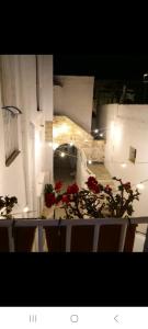 Blick in ein Zimmer mit roten Blumen auf einem Tisch in der Unterkunft La Corte delle Arti in Matino