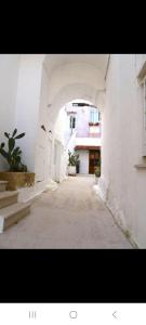 einen leeren Flur mit einem Bogen in einem Gebäude in der Unterkunft La Corte delle Arti in Matino