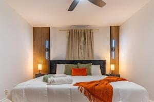 Christmas special, Cozy Luxe Escape, Raleigh 2BR Getaway, Sleeps 4, Pets, Kids & Business Travelers Welcome, Holiday deal في رالي: غرفة نوم مع سرير أبيض مع بطانية برتقالية عليها