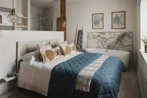 a bedroom with a large bed and a bath tub at Kennet in Marlborough