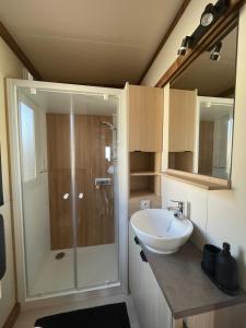 ein Badezimmer mit Dusche und weißem Waschbecken in der Unterkunft Bungalow vue mer panoramique in Saint-Raphaël