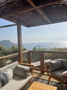 einen Balkon mit Sofas und Meerblick in der Unterkunft Bungalow vue mer panoramique in Saint-Raphaël