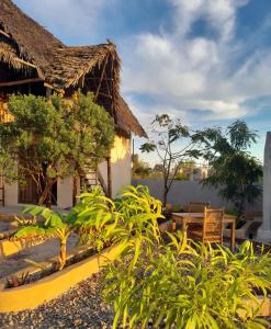 un jardín frente a una casa con mesa y sillas en Serenity stay Kizimkazi, en Kizimkazi