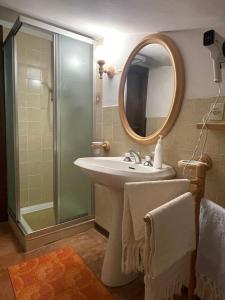 een badkamer met wastafel en douche met spiegel bij Nido delle Alpi by SMART-HOME in Pietraporzio