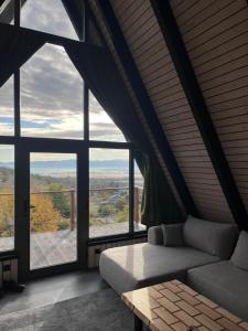 a living room with a couch and large windows at A frame Miška in Nána