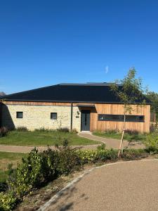 a large brick building with a black roof at Horslip in Marlborough