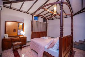 a bedroom with a canopy bed with a desk and a mirror at Mountvilla Exquisite 4-Bedroom Luxury Retreat with Private Pool in Galle