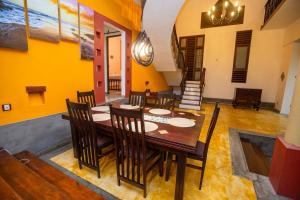 a dining room with a wooden table and chairs at Mountvilla Exquisite 4-Bedroom Luxury Retreat with Private Pool in Galle