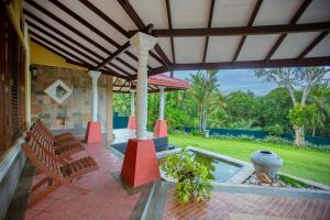 a patio with benches and a fountain on a house at Mountvilla Exquisite 4-Bedroom Luxury Retreat with Private Pool in Galle