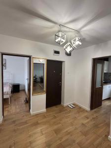 an empty living room with a ceiling with lights at Wine Road Apartment in Gura Vadului