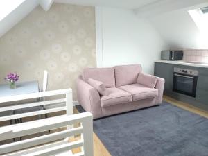 a living room with a pink couch and a kitchen at Views for miles in Monmouth