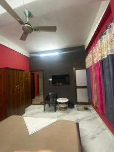 a room with a bed and a ceiling fan at Haven Stay in Dibrugarh +4 photos