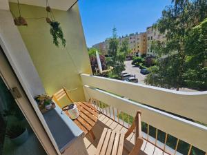 a balcony with a bench and a view of a street at Apartament Dzień dobry in Wałbrzych