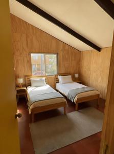 Futa House في فيوتاليوفيو: غرفة بها سريرين ونافذة