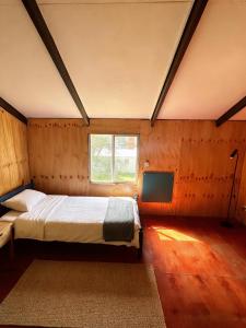 Futa House في فيوتاليوفيو: غرفة نوم بها سرير وتلفزيون في الغرفة