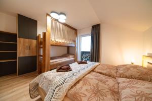 een slaapkamer met een bed en een stapelbed bij Villa Merry in Vysoké Tatry