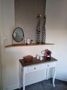 a dressing table with a mirror on a wall at De Oude Bakkerij in Onderdendam +17 photos
