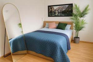 a bedroom with a bed with a blue comforter at Quiet & Modern Studio near Tram & River Lech in Augsburg