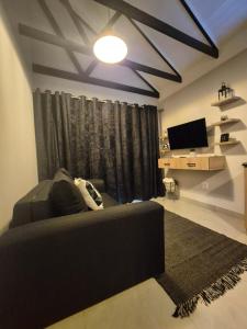 Una sala de estar con un sofá y un televisor de pantalla plana. en At-Nine, en Welkom 4 fotos más