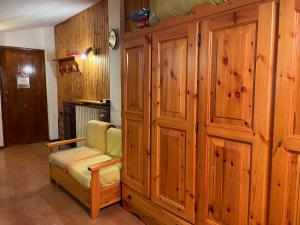 een woonkamer met houten wanden en een stoel bij Nido delle Alpi by SMART-HOME in Pietraporzio