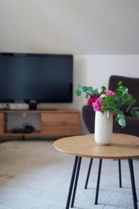 Un jarrón de flores sobre una mesa en una sala de estar. en Ferienwohnung-bei-Familie-Kuehl, en Fehmarn